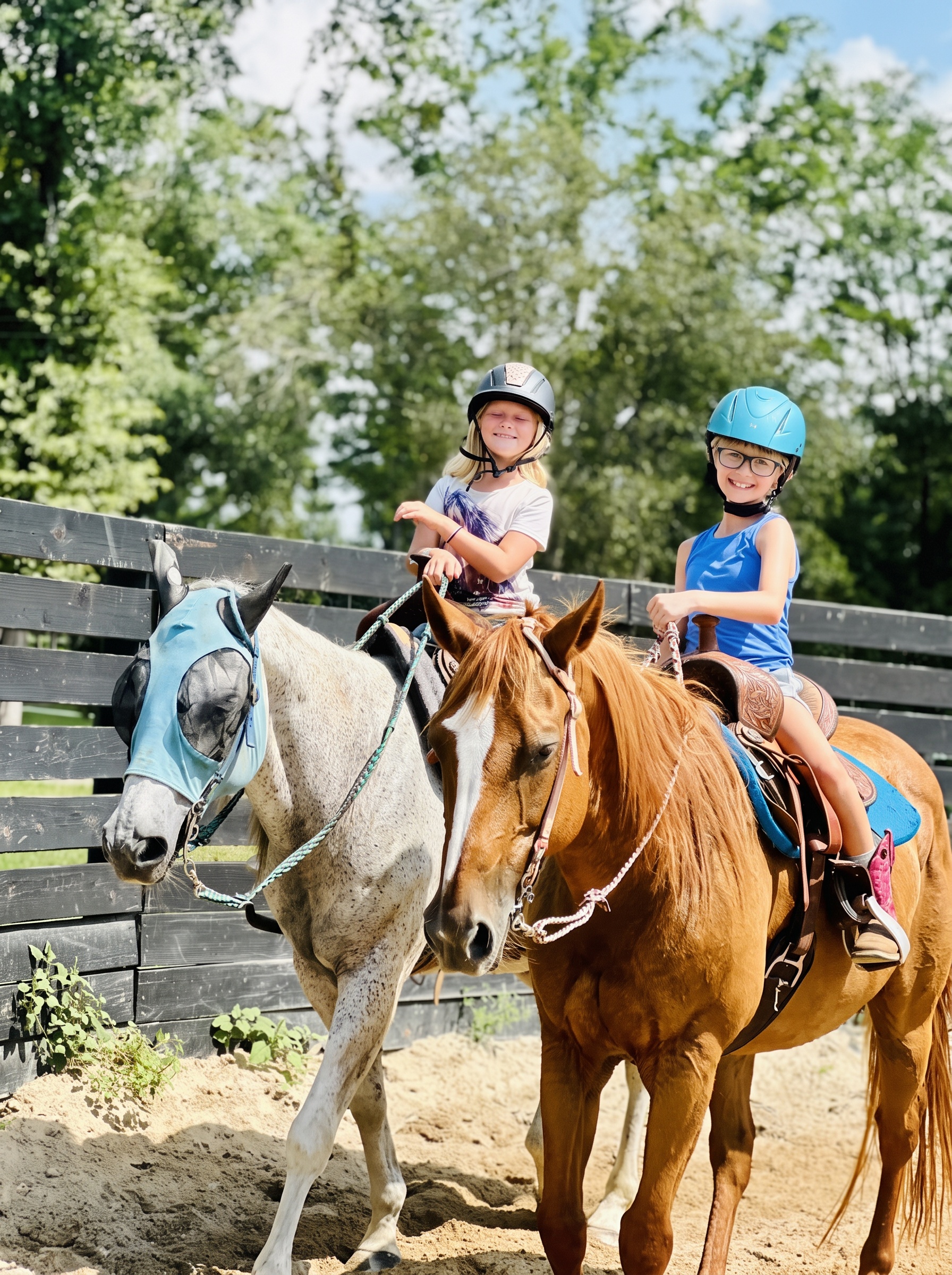 Two smiling students on horseback after their lesson
